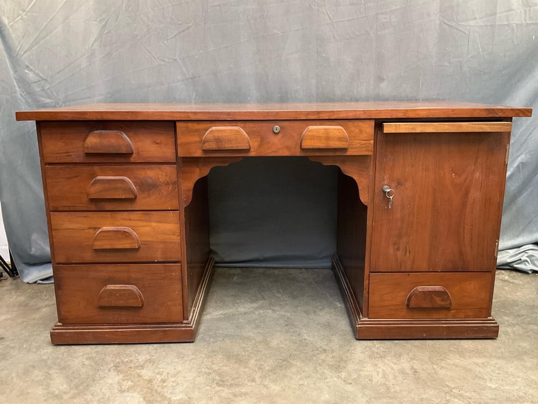 Desk: Mid-20th century walnut bench-made kneehole pedestal desk with six drawers including central locking drawer, one locking door and pull out writing slide. Includes working keys for both locks. Some