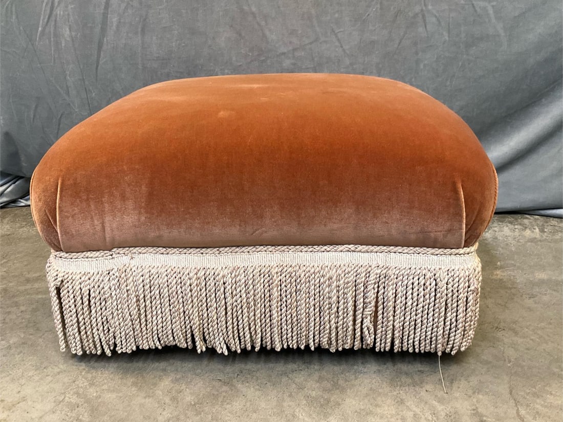 Ottoman: Late 20th century modern ottoman upholstered in an orange brown rust velvet with a bullion fringe skirt. Good condition. Measures 30 inches wide x 30 x 17 inches tall.