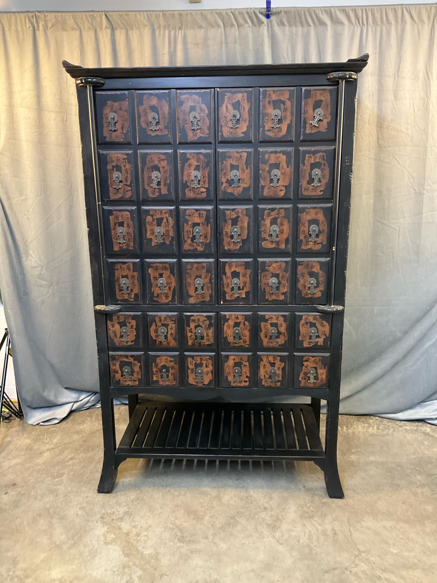 Entertainment Center: Late 20th century modern Chinese style reproduction entertainment center/armoire with upper and lower sections. Garment hanger pole in upper section with removable shelf and sliding removable back