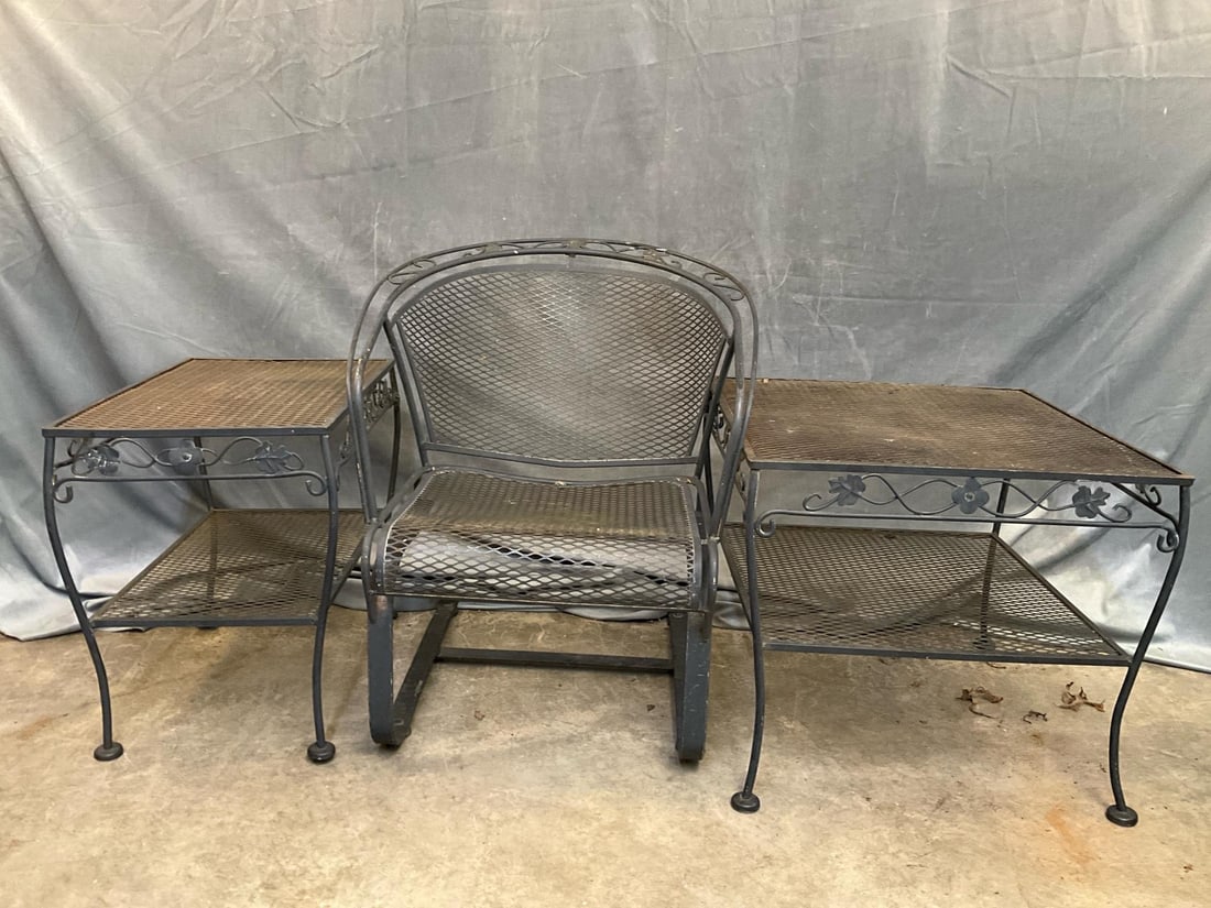 Outdoor Furniture: Three pieces of late 20th century wrought iron outdoor furniture. Two two tiered tables and one "bouncer" armchair. Bent table leg, otherwise good used condition. Rectangular table measures 24.25