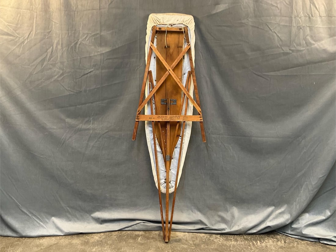 Ironing Board: Early 20th century National Washboard Company "Our Own" No. 4 wooden ironing board. Missing standing support mechanism. Measures 48 inches wide x 13 x 32 inches tall.