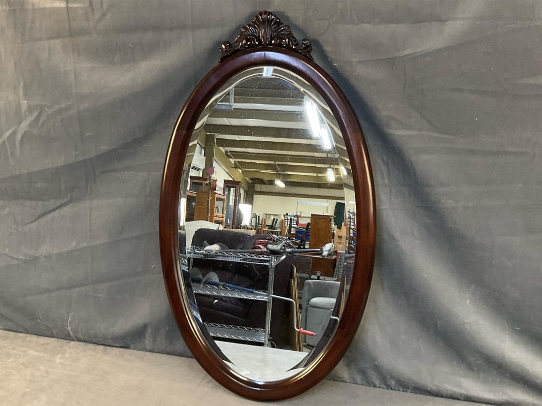 Wall Mirror: Modern Bombay and Company wall mirror with carved Rococo style shell crest. Good condition. Measures 18.5 inches wide x 1 x 38.5 inches tall.
