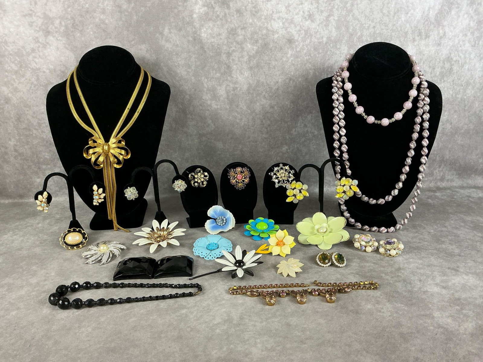 Costume Jewelry: Twenty four pieces of vintage costume jewelry. Includes necklaces, clip-on earrings, and brooches. Most are unmarked but some are made by Monet and Sara Coventry. One brooch is missing some stones,