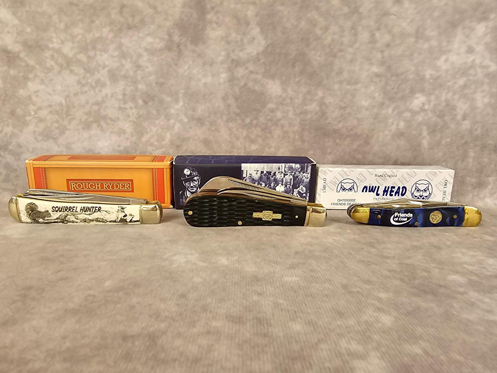 Collectible Knives: Three modern knives in original boxes. Rough Ryder Squirrel Hunter, Rough Ryder Coal Miner, and an Owl Head Friends of Coal knife. Good condition. Largest box measures 4.75 inches long x 1 x 1.5