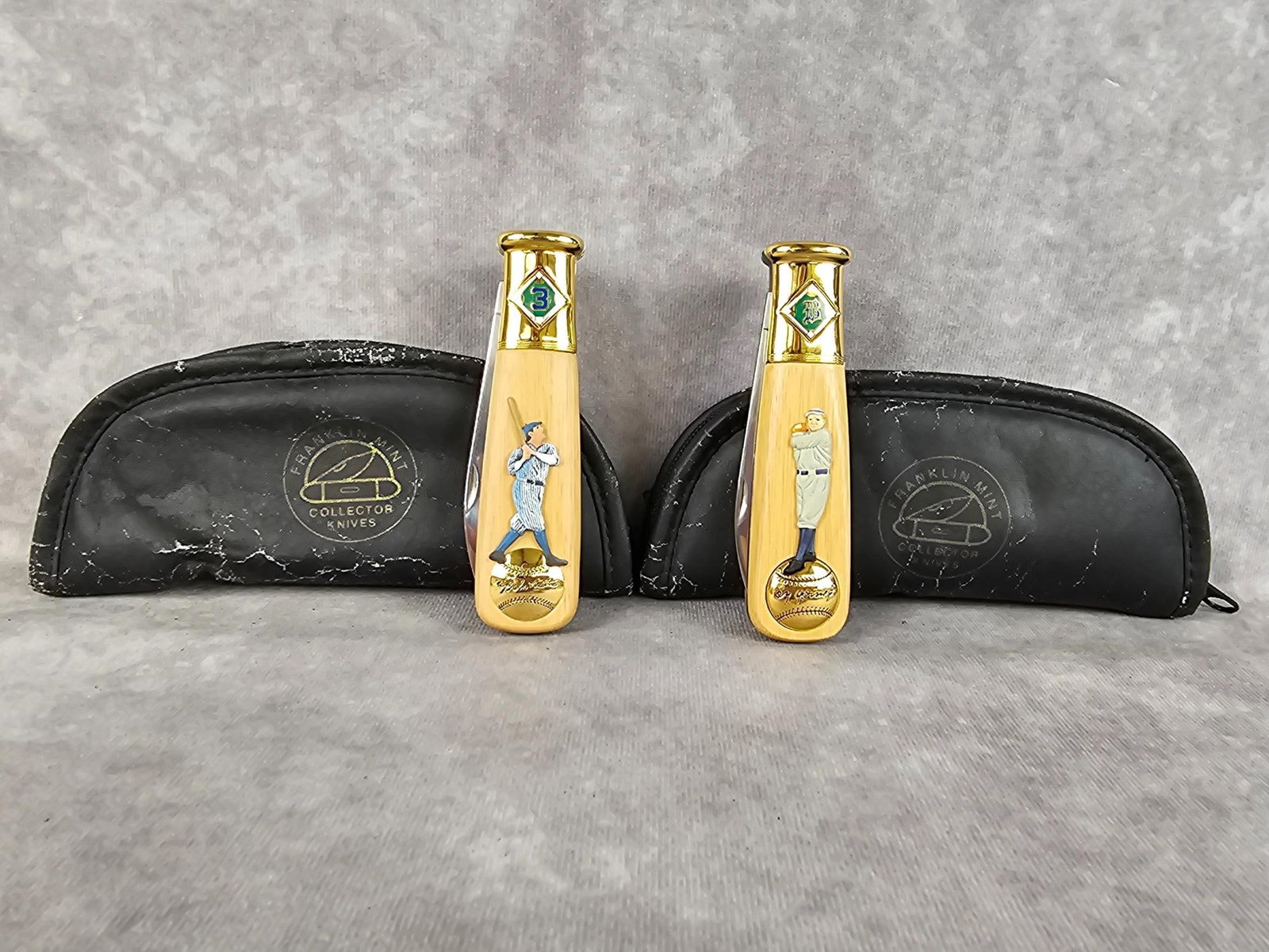 Baseball Commemorative Knives: Two 1990s Franklin Mint baseball collectors knives. 1996 Babe Ruth and 1998 Cy Young wood handle knives with cases. Knives in good condition, cases have wear. Each knife measures 4 3/8 inches long