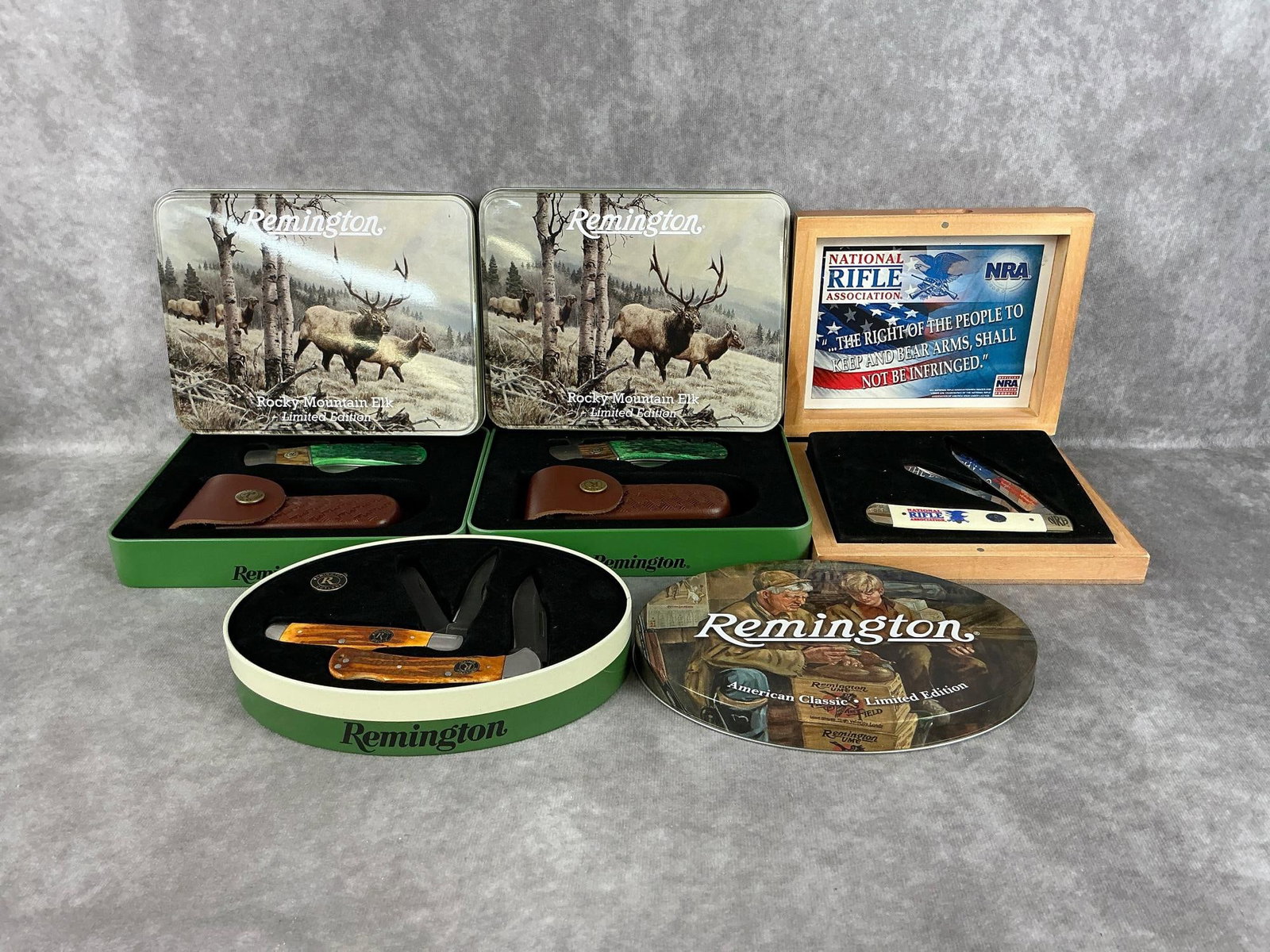 Remington & Steel Warrior Knives: Four modern collectible knives, three Remington tins and one Steel Warrior NRA in wooden box. All knives are new and in good condition. Largest tin measures 7.25 inches wide x 5.5 inches tall.