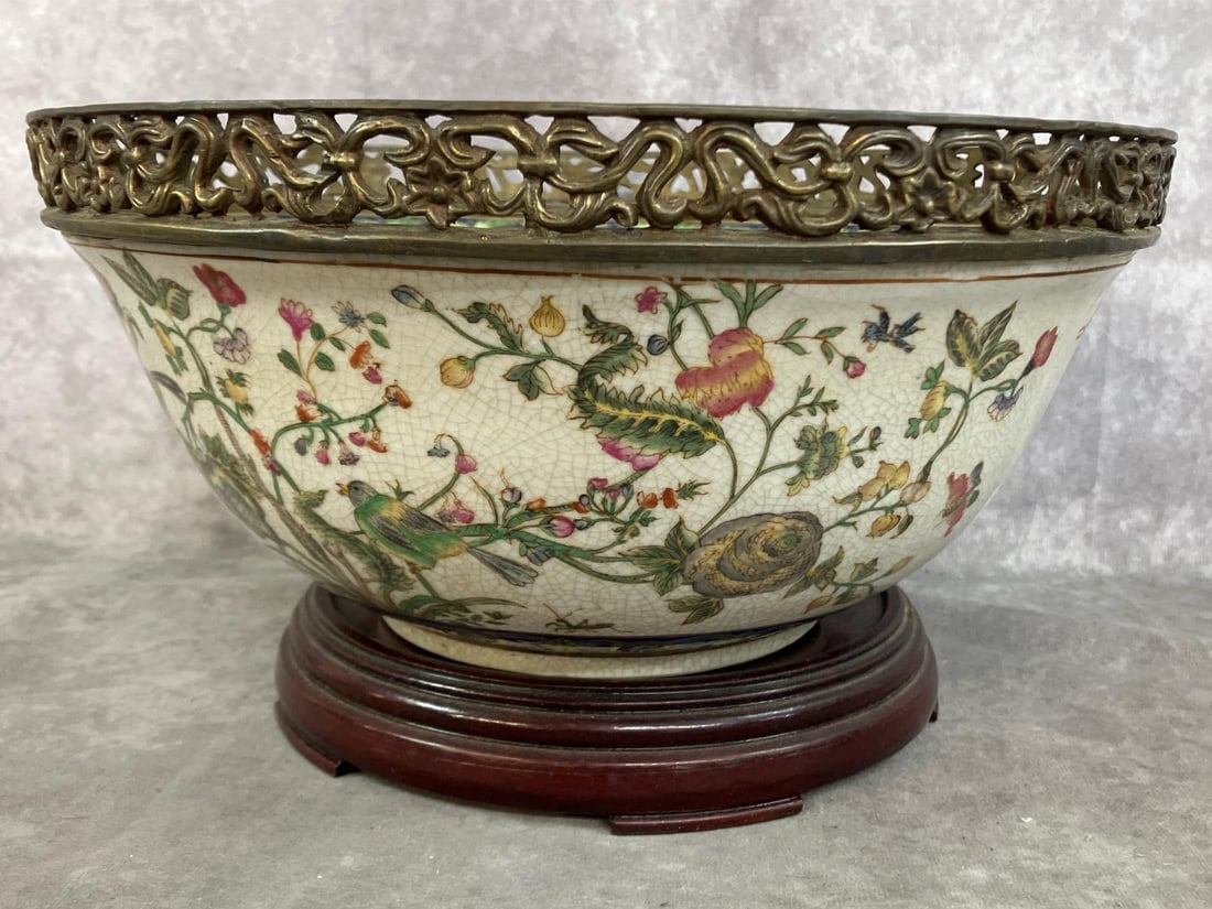 Chinese Rose Medallion Bowl Replica: Mid to late 1900's Chinese export replica bowl. Rose Medallion with floral and bird motifs, ornate open work gilt metal rim. Sits on wooden stand. Crazing present, otherwise in good condition.