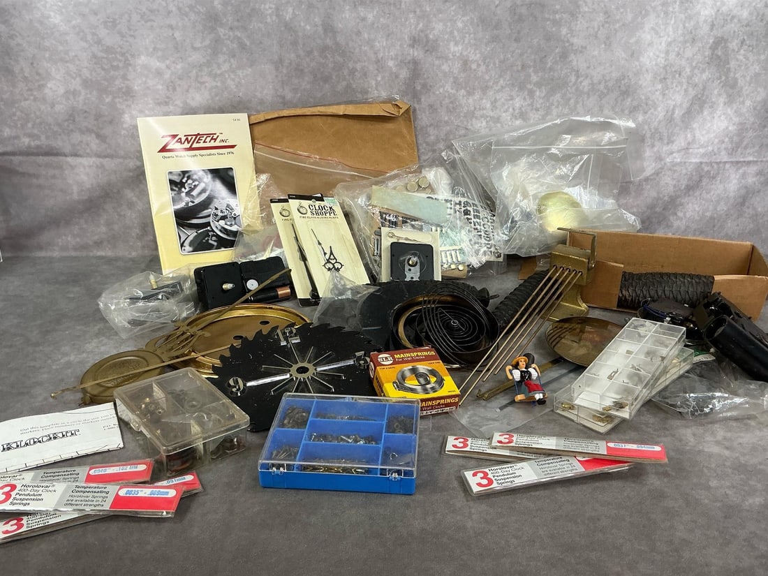 Clock Making Parts: Large collection of vintage clock parts. Three boxes of clock faces, springs, hands, mechanisms, pendulums and much more. Some used, others in original packaging. Largest box measures 16 inches wide
