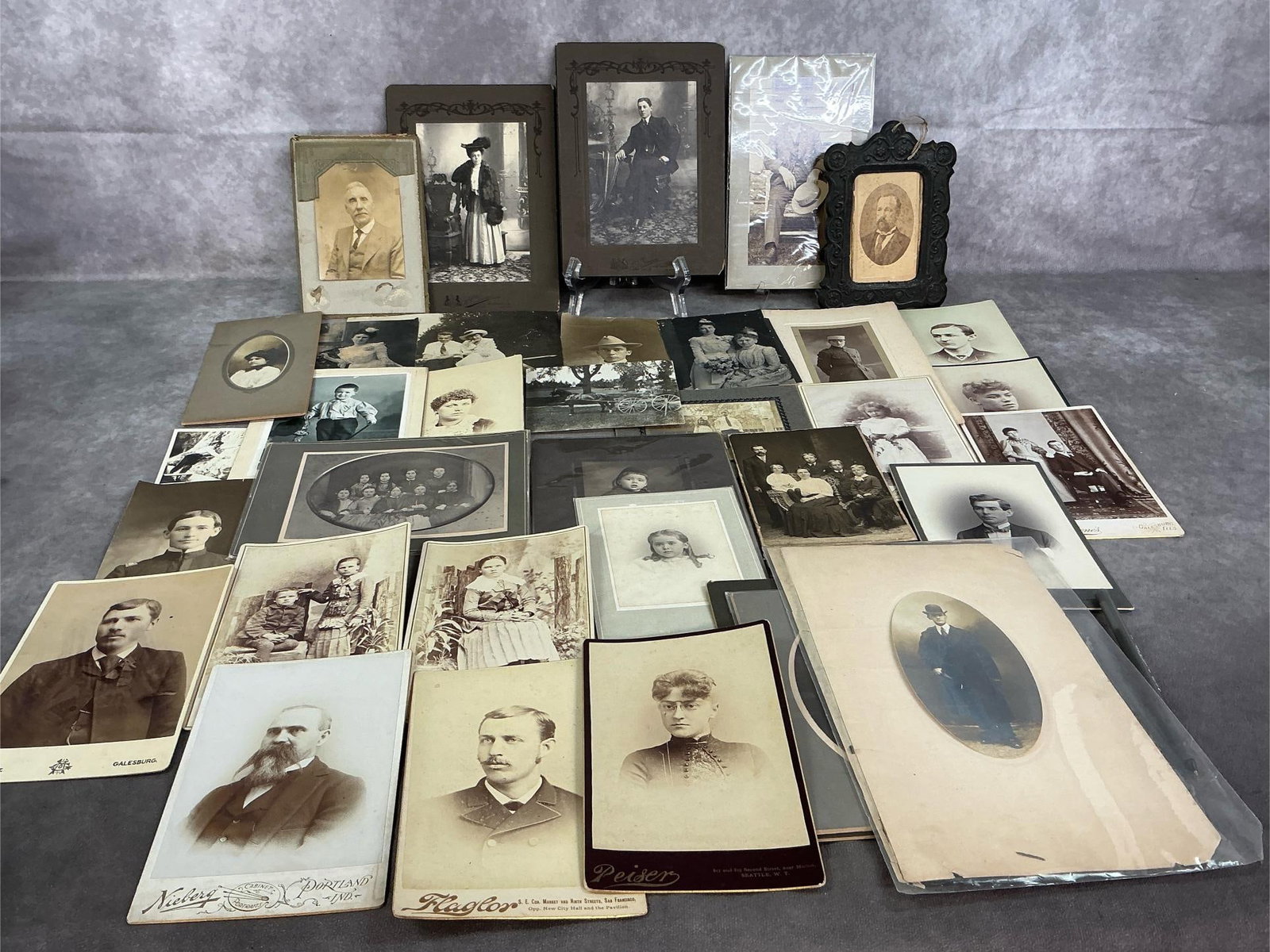 Antique Portraits: Over sixty cabinet card portraits and photographs from 1885-1940. Individuals, families, and few snapshots. Some fading and wear present. Largest measures 6 inches wide x 10 inches tall.