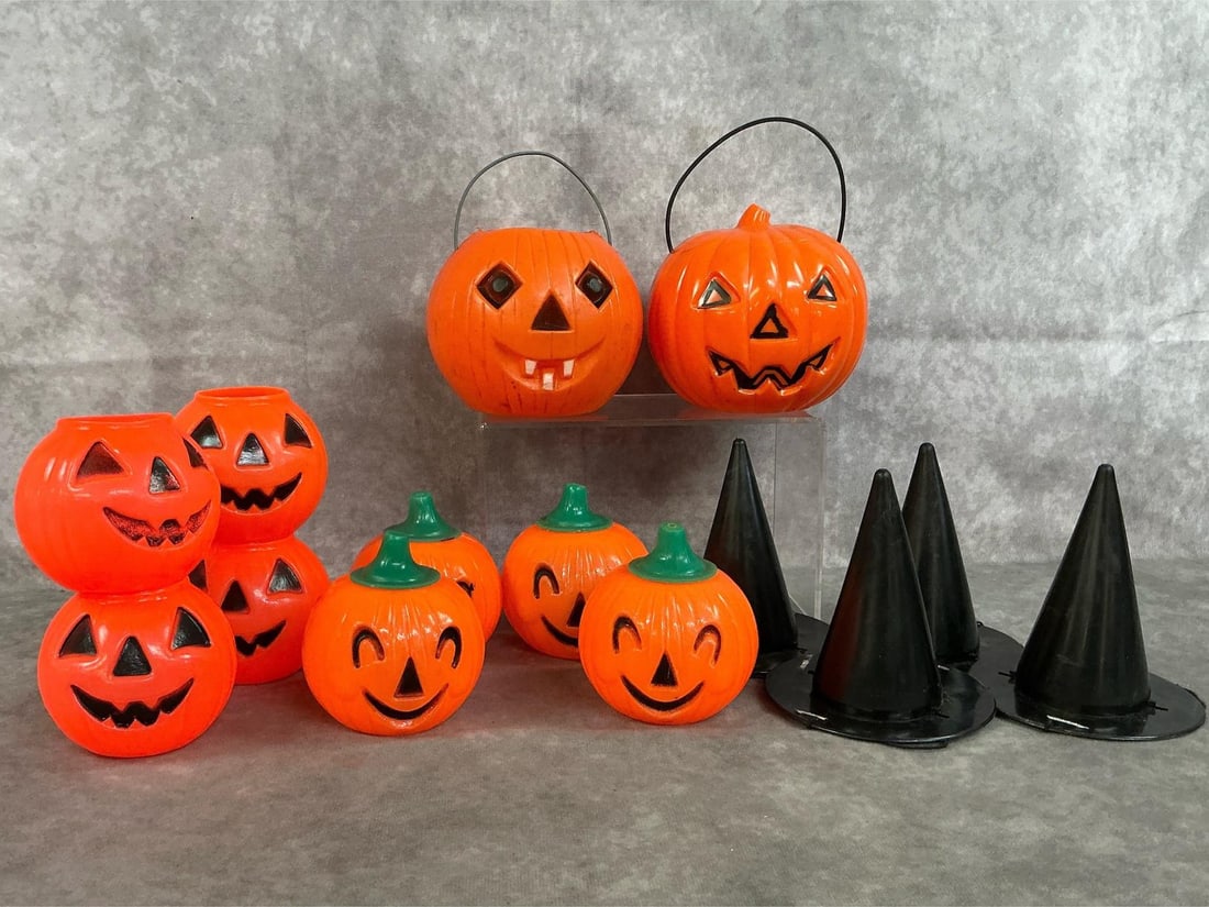 Jack o' Lanterns & Witch Hats: Fourteen mid to late 1900's Halloween party items. Four black plastic hats, eight small plastic pumpkins and two medium size Jack o Lantern pumpkins. In good condition. Largest pumpkins measure 4.25 i