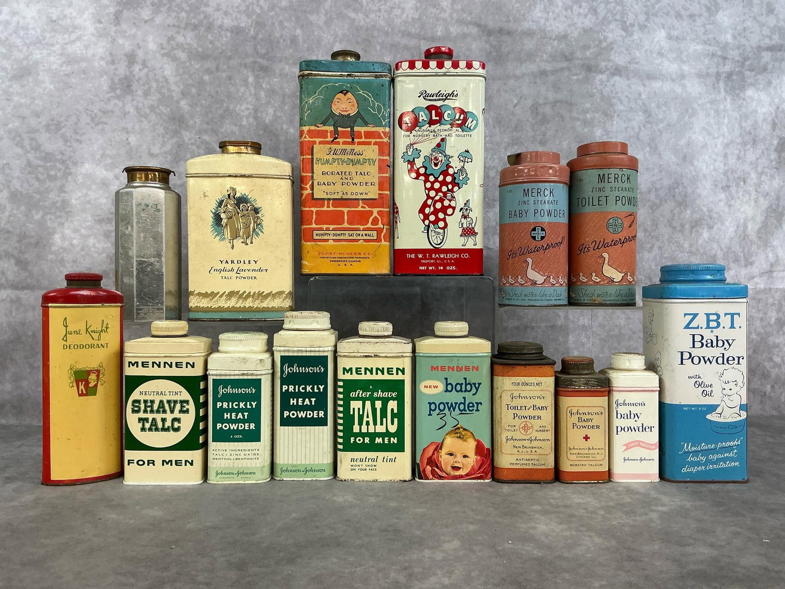 Vintage Talc & Baby Powder Cans: Sixteen mid 1900's tins of powder. Includes baby powders by McNess Humpty-Dumpty, Rawleigh's, Johnson's, Merck, and more. Also Yardley Talc, Mennen Men's Talc, June Knight deodorant and more. Rust