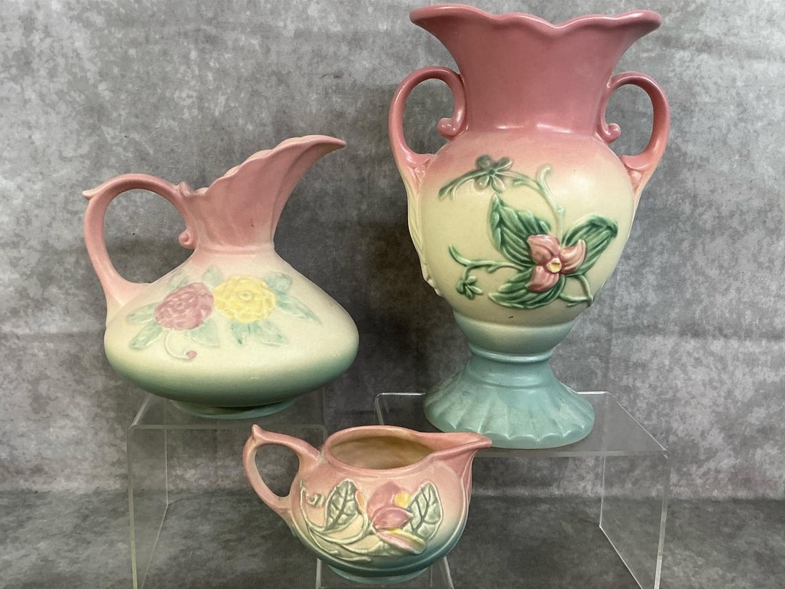 Hull Pottery: Three mid 1900's art pottery. Hul's Wildflowers art pieces in pastel pink, blue, and yellow. Urn vase, pitcher vase and creamer. Urn vase has broken top edge, other pieces in good condition. Urn