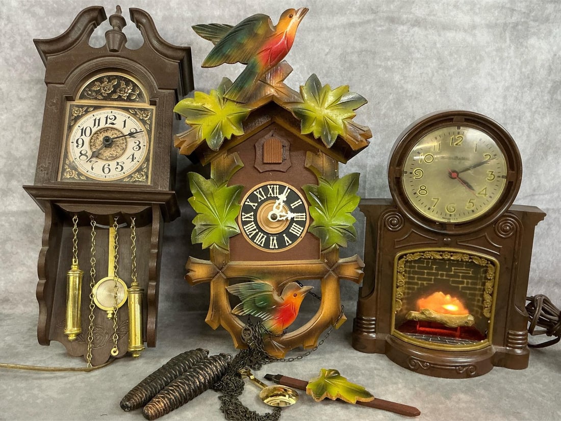 Vintage Clocks: Three mid to late 1900's clocks. Black Forest cuckoo clock with maple leaf and bird accents and pine cone weights. Master Crafters Bakelite novelty fireplace clock in working order. Spartus electric w