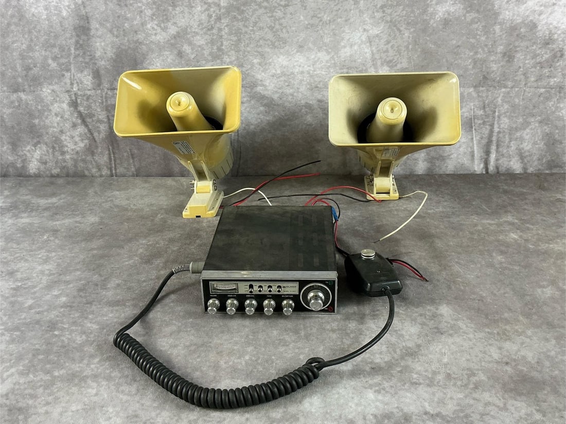 Midland CB Radio And Radio Shack Siren: Model 13-883 23-channel CB radio and 49-525A electronic siren by Midland and Radio Shack in black and white. Fair condition with heavy dust, yellowed plastic casing, surface scuffs, and cut exposed
