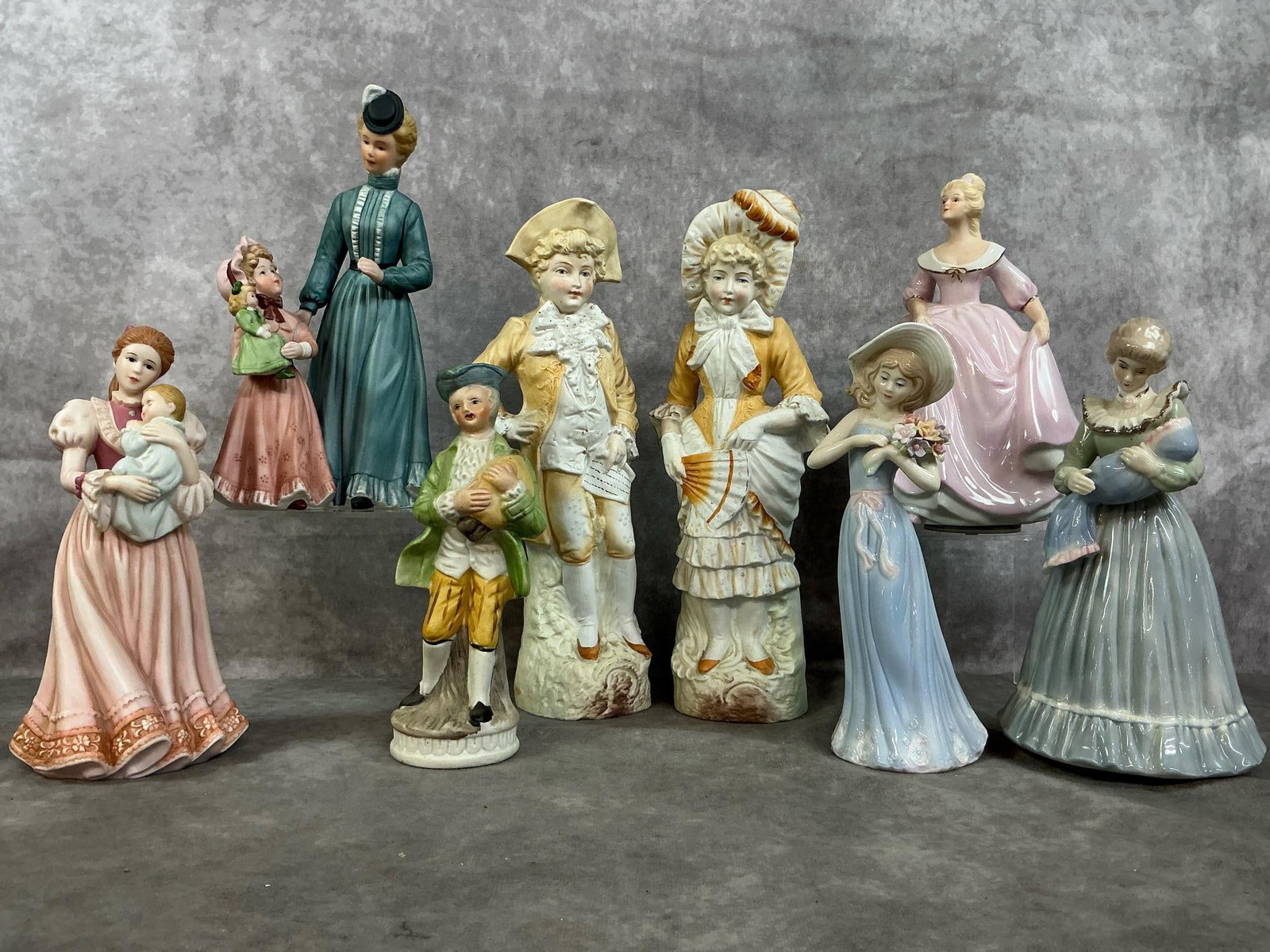 Porcelain & Chalkware Figures: Eight late 1900's figurines. Includes German bisque, painted porcelain figures, and glazed porcelain. Shiny pink dress lady and blue/ green lady with baby, have working music boxes. In good