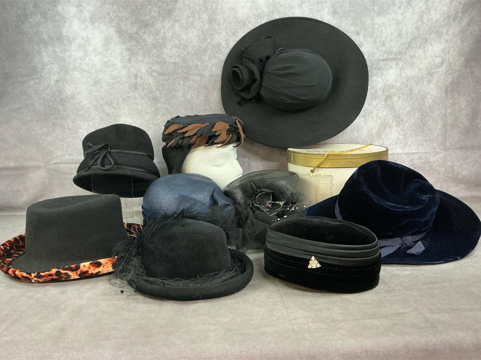 Black & Blue Hats: Nine late 1900's women's hats. Including velvet, brushed felt, straw and fabric. Hatbox from Horne's of Roanoke Va. in good condition. Black fabric hat measures 14 inches wide x 16 x 4.5 inches tall.