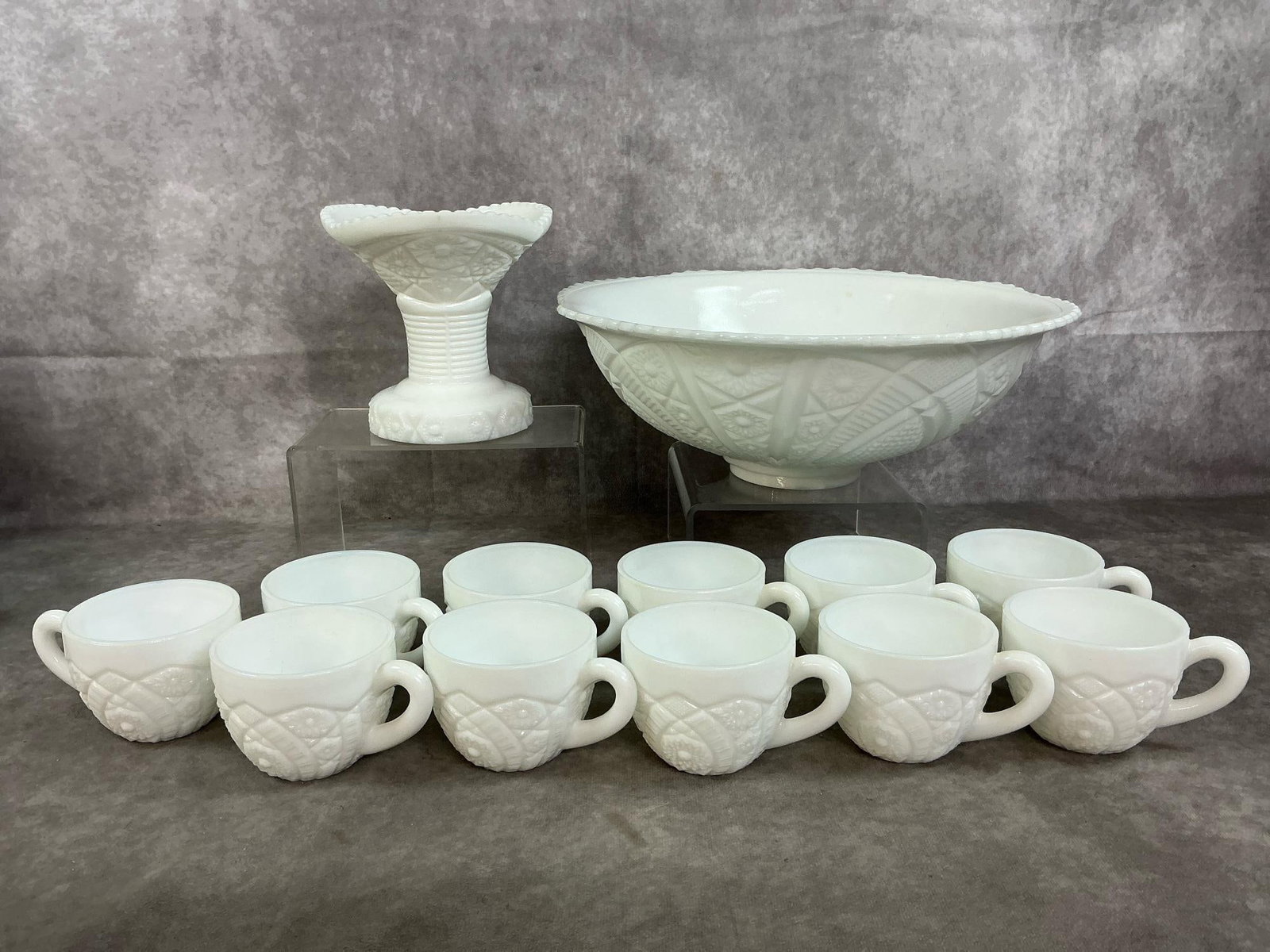 Old Quilt Pattern Punch Bowl & Cups: Thirteen mid 1900's McKee Concord milk glass. Punch bowl, pedestal base, and eleven cups in "Old Quilt" pattern. In good condition. Punch bowl measures 13 inches in diameter x 4 inches tall.