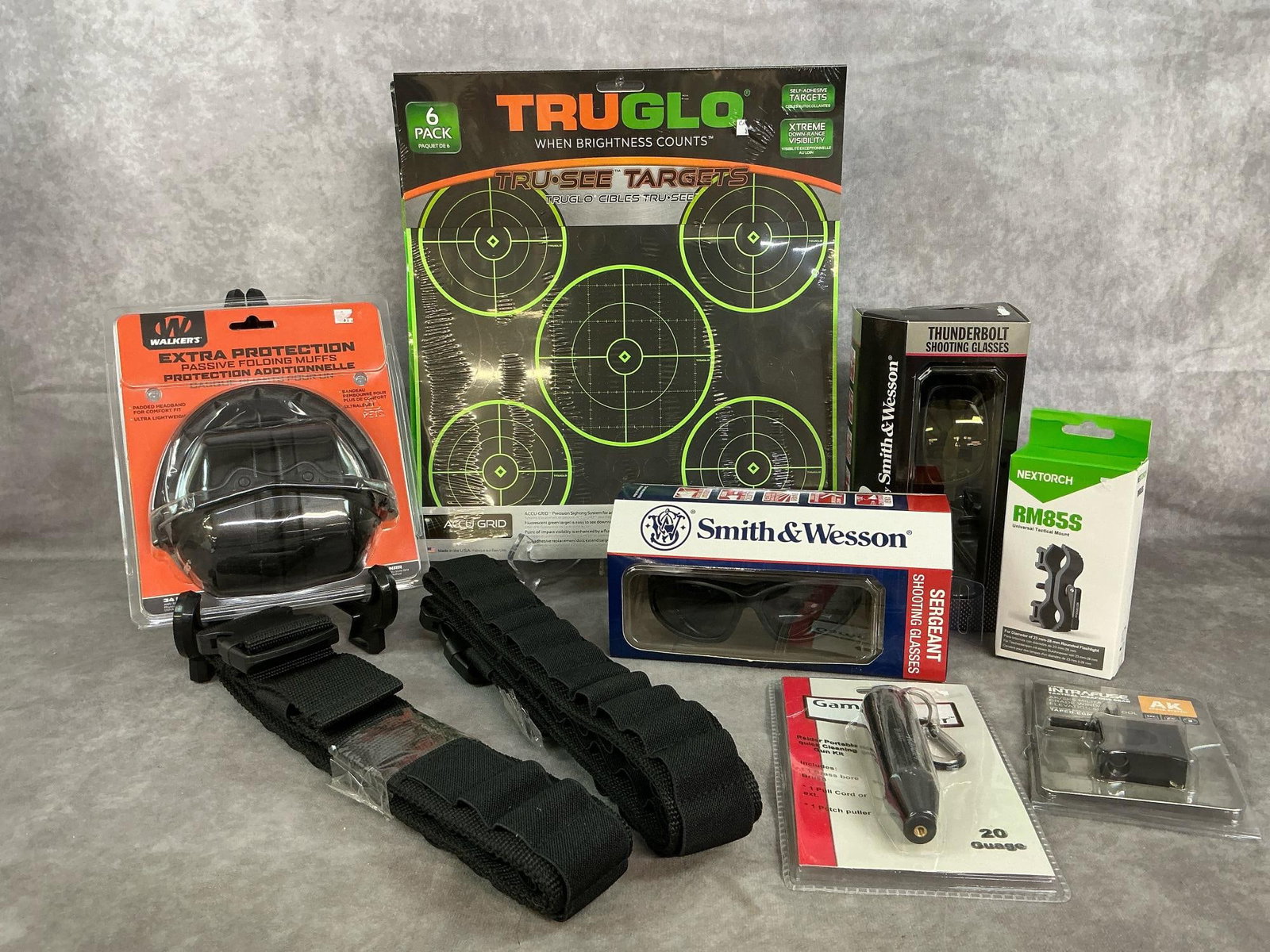 Shooting Gear: Eleven unused shooting items. Three TruGlo targets, Walker's ear muffs, two pair of shooting glasses, two shotgun scabbards, sight tool, and more. In original boxes. Targets measure 12 inches wide x