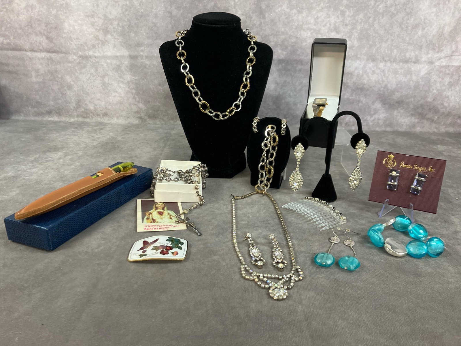 Necklaces, Earrings, Bracelets, & More: Fifteen late 1900's to modern age jewelry. Rhinestone crystal set, Napier open link set, Bay Studio watch, and rosary necklace. Includes fountain pen in leather case, purple and silver Premier