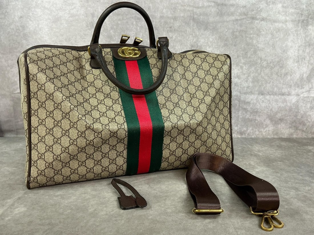 Gucci Duffle Bag: Gucci Savoy modern duffle bag reproduction. Tan and brown with red and green stripes, leather accents. Includes shoulder strap. Small scratched area, otherwise in good condition. Measures 17 inches