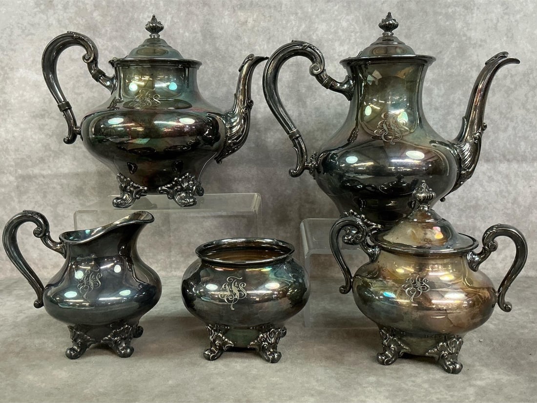 Silver Plated Tea & Coffee Service: Five piece mid 1900's silver plated tea or coffee service. Reed & Barton with deep blue and violet patina, has ornate handles, lids, and feet. In good condition. Coffee pot measures 10 inches wide