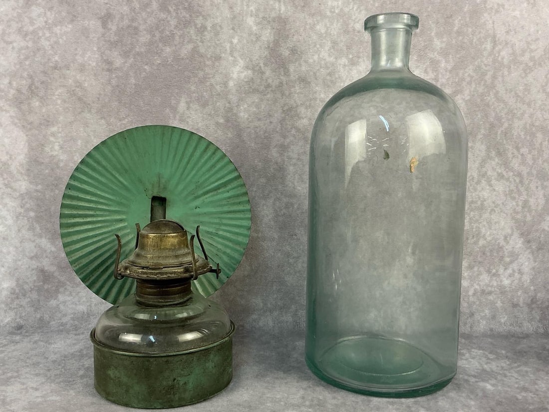 Apothecary Bottle & Oil Lamp: Two vintage items. Includes an oil lamp with refactor tin and an apothecary chemical/pharmaceuticals bottle. The bottle does have several chips otherwise both in good condition. Apothecary bottle