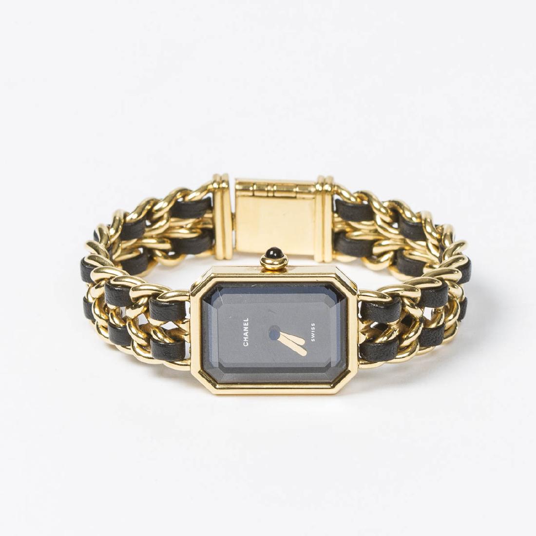 Chanel Premiere M: Chanel Premiere M in Black/Yellow Gold Plated. Gold tone with Black interlaced leather Bracelet. Excellent condition. Black Dial. Dimensions Dial:20*25mm / Bracelet:14,5cm. Weight of 49,8g. Jewelry cl