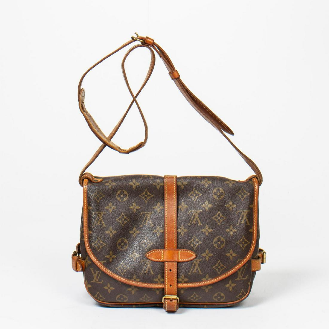 Louis Vuitton Saumur 25: Pre-loved Louis Vuitton Saumur 25 in Brown coated Monogram Canvas with Vachetta leather Strap. The hardware is in Golden Brass. Dimensions (L*H*D in cm): 25*21*7cm. Brand Production Code : AR1901. Vac