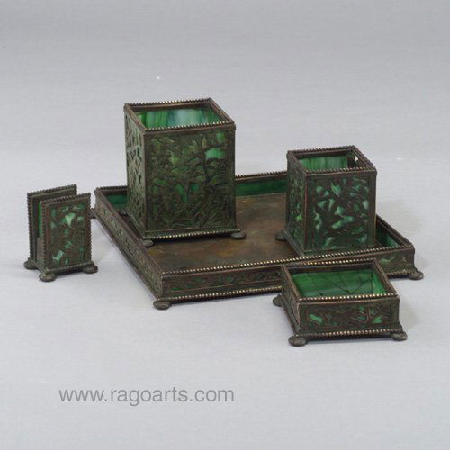 APOLLO STUDIOS five-piece smoking set i: APOLLO STUDIOS five-piece smoking set in the style of Tiffany, with pierced panels of flowers covered in verdigris patina and lined with green slag glass: cigarette box, match box, match holder, ashtr