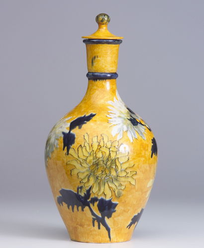 JOHN BENNETT Covered bottle painted with white, pi: JOHN BENNETT Covered bottle painted with white, pink and yellow chrysanthemums with cobalt leaves on a cadmium yellow ground. Restored chip on lid. Signed J. Bennett/N.O.N.Y/6 Nov 1888/Harrison/Pres.