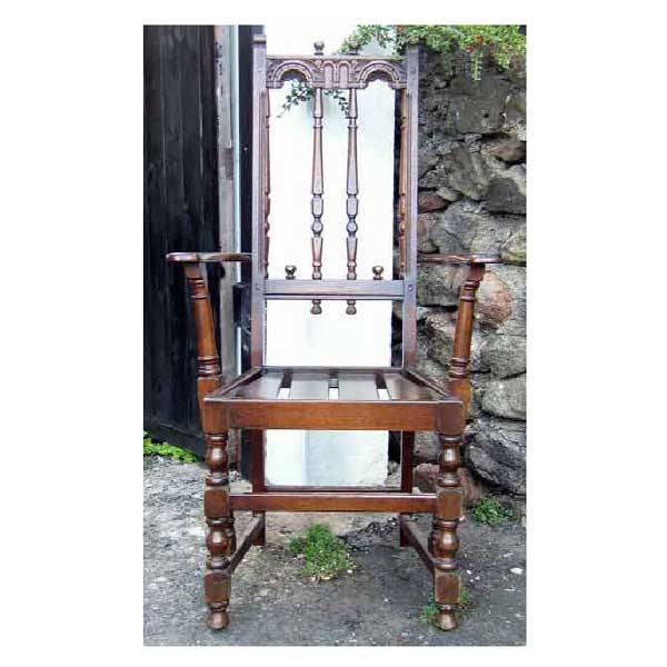 Furniture - A pair of Derbyshire style Ercol oak: Furniture - A pair of Derbyshire style Ercol oak side chairs, the backs with twin turned spindles beneath arched carved rails, with shaped arms supported on baluster columns, above slatted seats raise