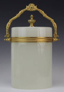 French Opaline with Gilt Handle Cylinder 8" Biscuit Box: Vintage French opaline box. Crafted of white opaline glass. Mounted with gold gilt hardware and floral handle. Round cylinder form with gilt finial. Measures 8 3/4" x 4 3/4". Good condition with wear