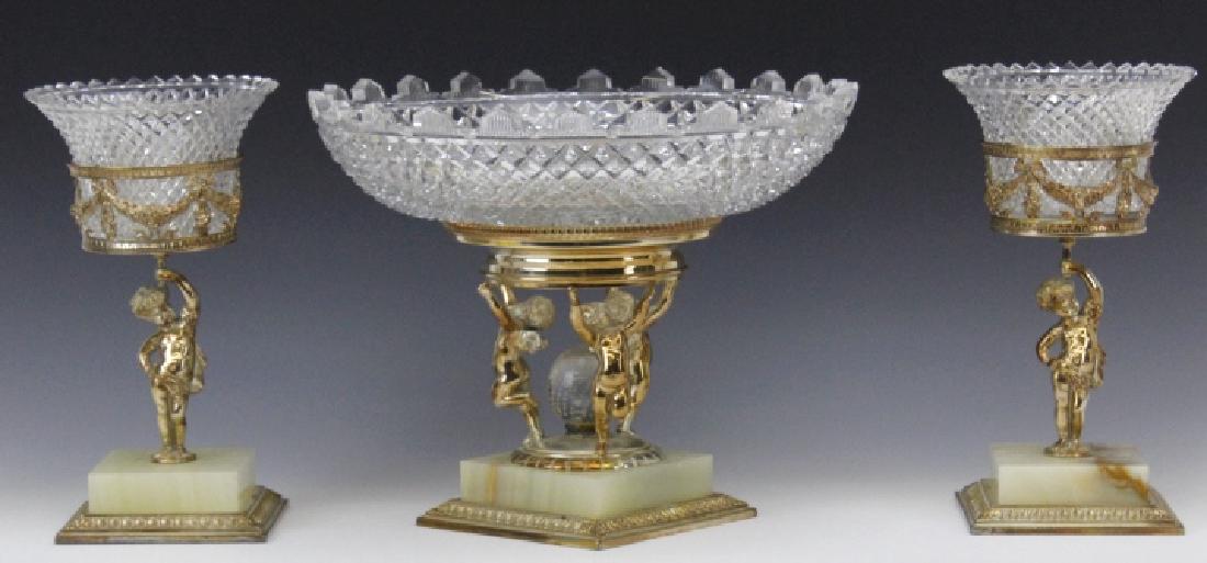 Pairpoint Figural Cherub Cut Glass Garniture Set: The pieces of this rare three piece matching table garniture or mantle set are composed of cut glass and blonde onyx with silver plated mounts. The glass is beautifully cut with one of the companies i