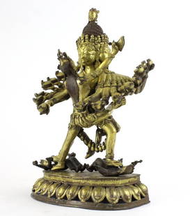 Nepalese Gold Gilt Hevajra Bronze Statue BASS MUSEUM: Antique Nepalese (Chinese) gilt bronze figure of Hevajra and his consort Nairatmya in a ritual embrace. Standing on four armed figures bearing gifts atop a lotus base. SHAMVARA multiple faces with a