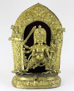 Antique Nepalese Jeweled Gilt Bronze Statue BASS MUSEUM: Antique Nepalese (Chinese) gilt bronze figure of a multi-armed god. Standing in a ritualistic pose atop prone figures on a lotus base. He has 6 arms holding ritual objects. Large repousse decorated