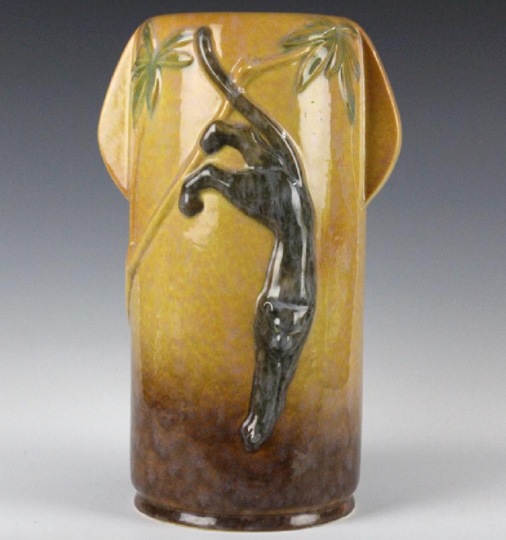 Roseville Pottery WINCRAFT PANTHER 10" Vase 290-11: Roseville American art pottery Wincraft panther vase. Features a tube shaped body with raised palm decorations as well as a leaping black panther. Base with raised Roseville mark. Measures 10.5" tall.