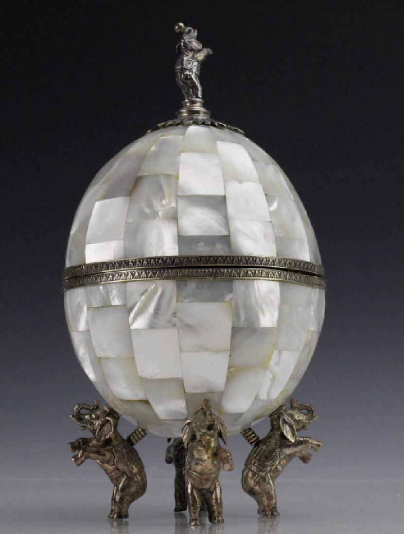 Maitland Smith Tessellated Lucky Elephant Egg Box: Maitland Smith egg form box. Features an egg form with mother of pearl tiles and a footed base. Each foot is represented by an elephant on its hind legs. The finial on the lid also features one of the