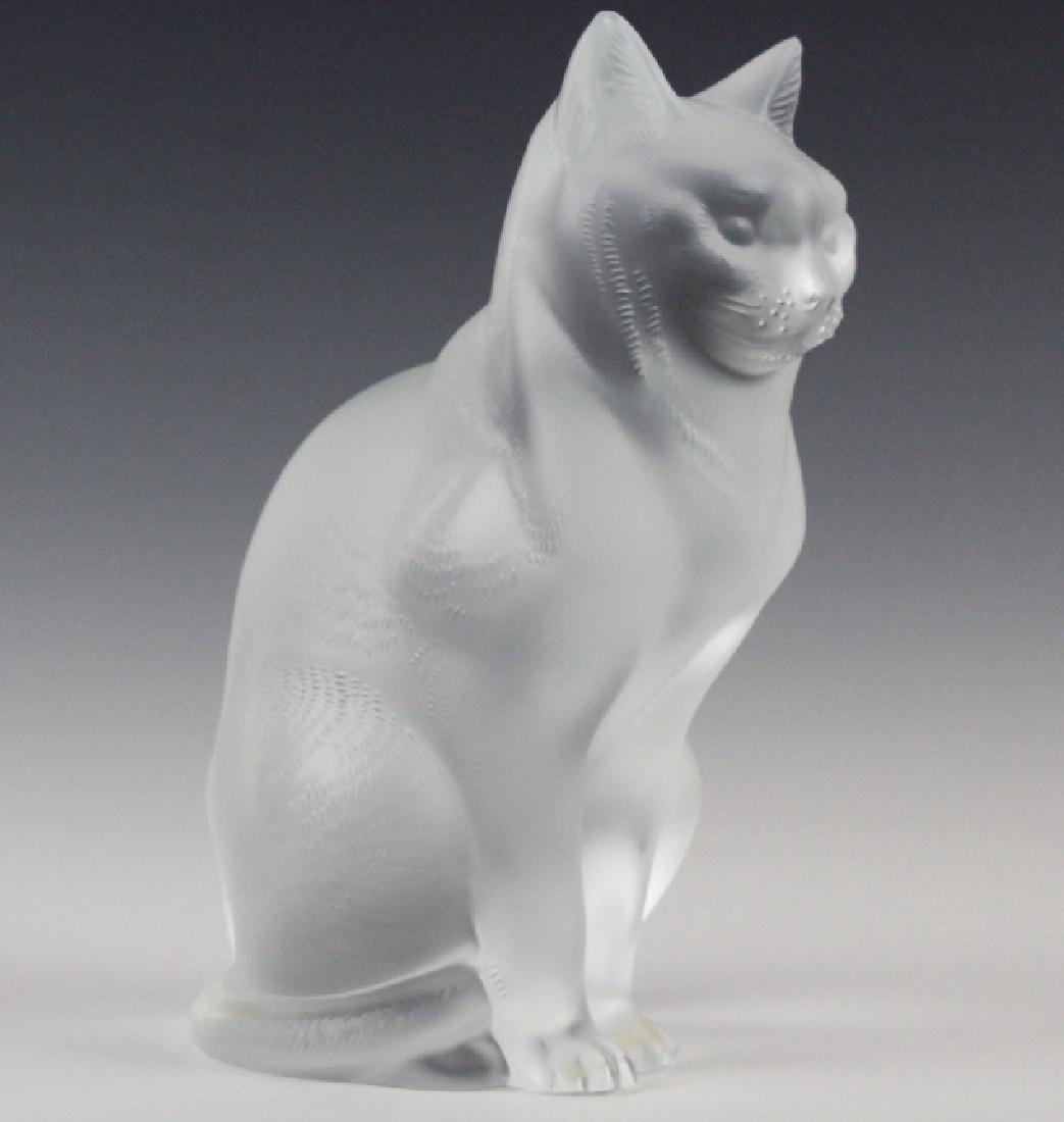 LALIQUE French Crystal Sitting Cat Glass Figurine: Crafted of fine quality French art glass with a frosted finish. Features a cool cat in a seated position. Signed Lalique France on bottom. Retains the original label. Measures 8 1/4" x 6". Very good c