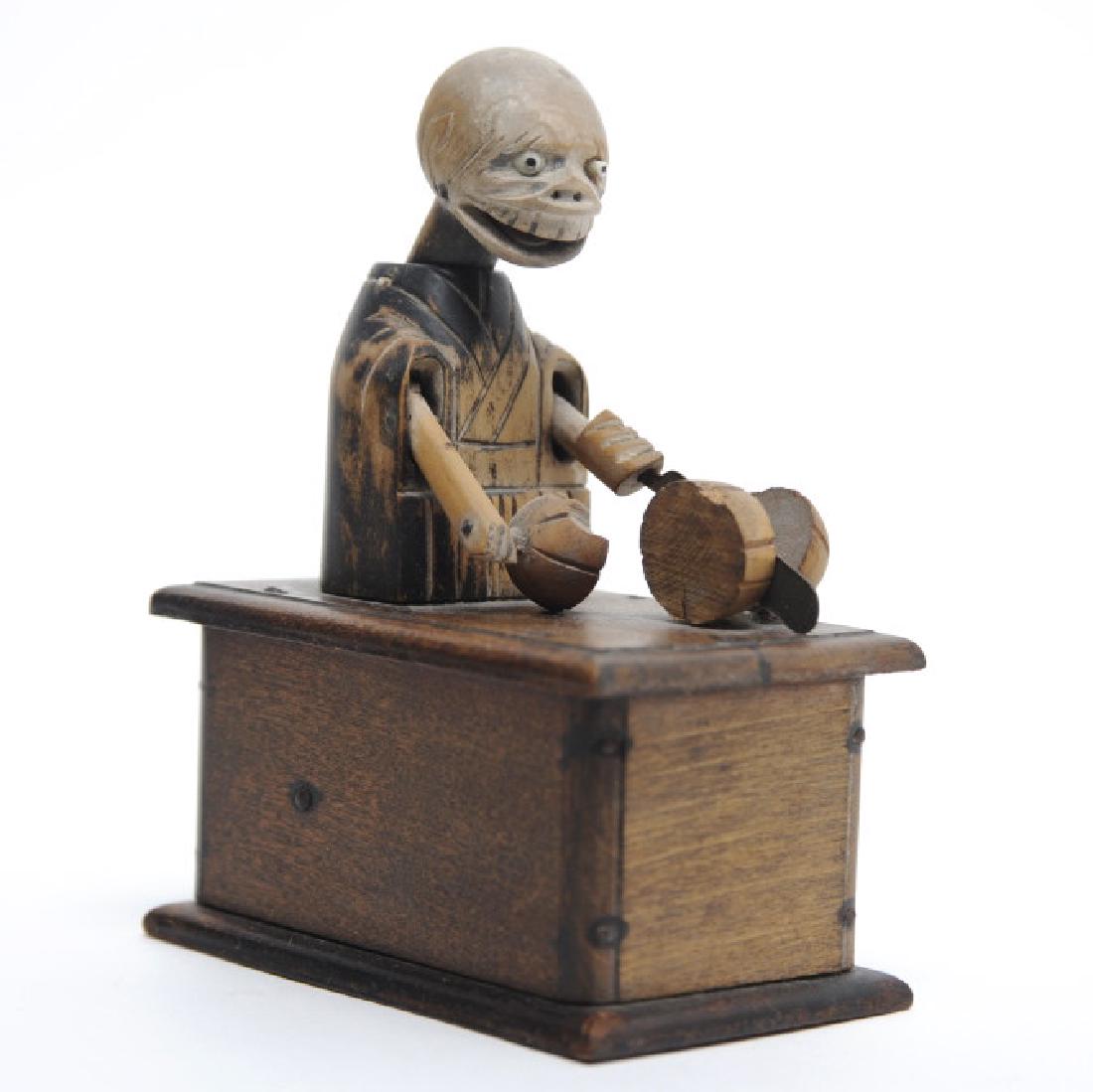 Antique Japanese Kobe Wood Articulated Eater TOY: Hand carved and stained wood lever operated toy with amusing action. Figure cuts and eats melon. Measures 4 1/2" x 3 1/2" x 2 1/2" Good condition with surface rubbing and loss. In house continental US