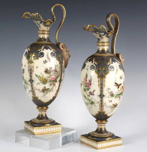 Antique Pair Royal Worcester Porcelain Urn Vases: Features all over decoration of colorful birds and blossoming branches against an ivory field. Blue and gold gilt borders with elaborate horned face handle details. Partially obscured Royal Worcester