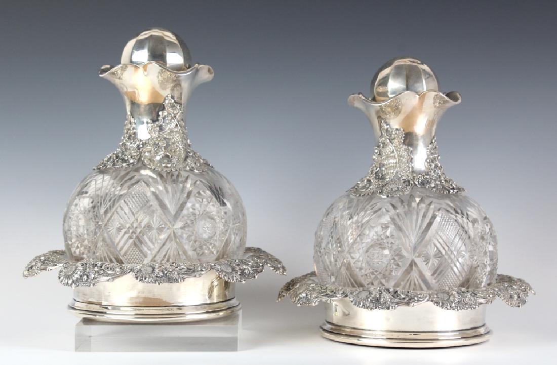 PAIR Cut Glass Sterling Silver Floral Decanter Set: Antique Art Nouveau era decanters with wine coasters. American Brilliant Period cut glass decanters with sterling silver mounts by Dominick & Haff. Features ornate floral work with flowers and fern sc