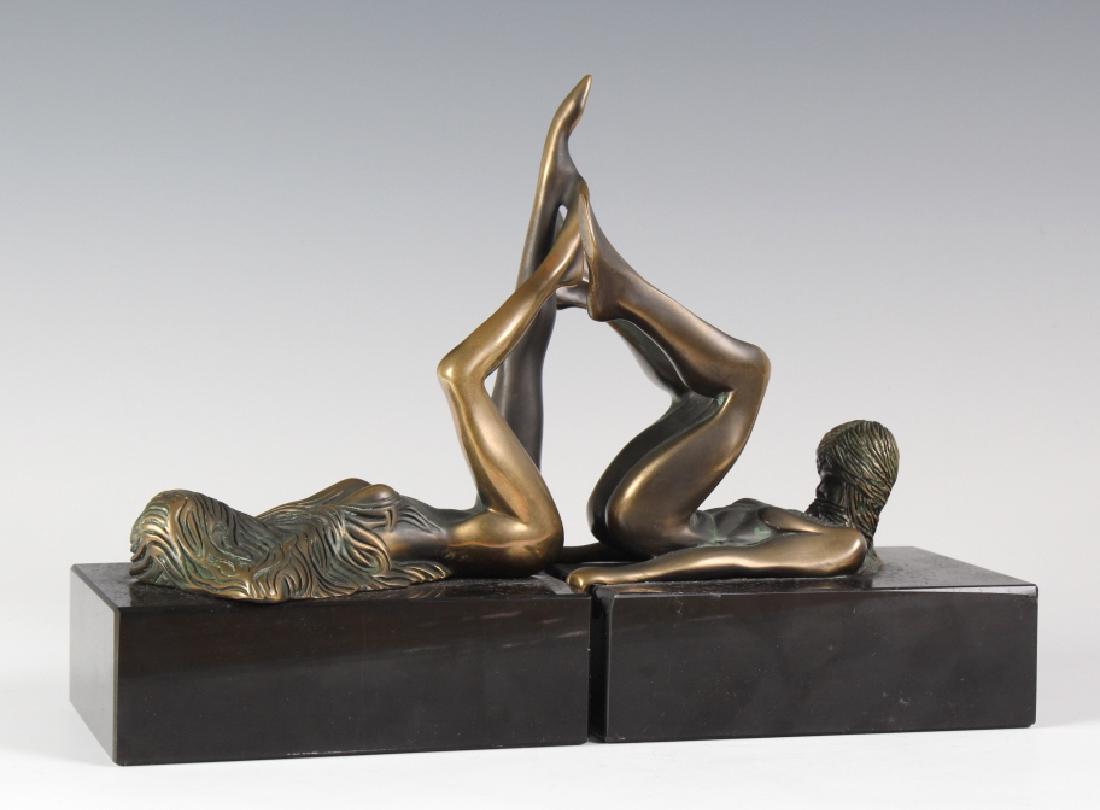 PR Bob Bennett Modernist Bronze Sculpture Bookends: Bob Bennett (20 century) American, Bronze sculptural bookends. Depicts the form of a nude woman, on her back, with legs up and bent as her hands grip the side of the black stone base, The other one is