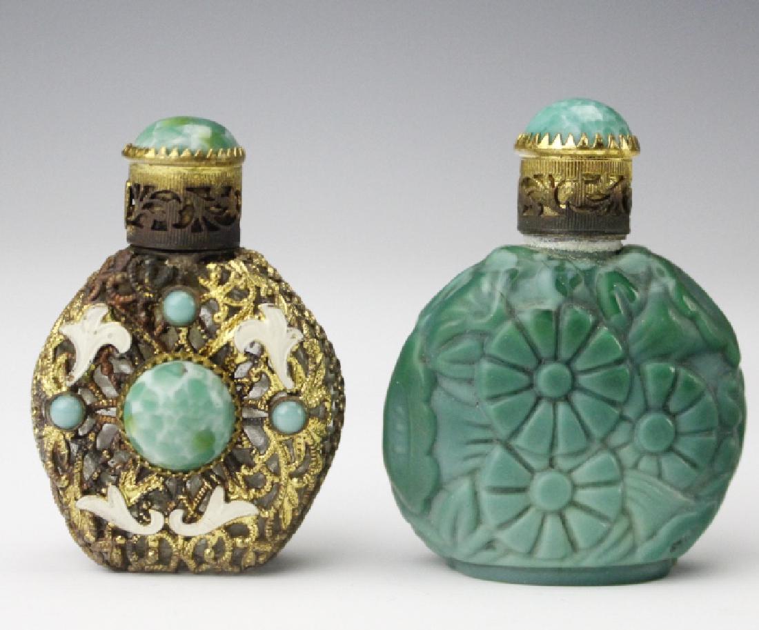 Vintage Czech Malachite Peking Glass Scent Bottles: Vintage glass and gilt metal scent bottles. Features a malachite glass with floral relief bottle as well as a glass bottle with reticulated metal, green glass cabochons, and enamel. Marked near lid. M