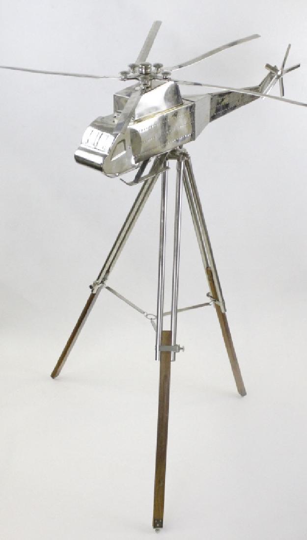 Articulated Helicopter, Chopper & Footed Wood Base: Whimsical vintage style metal helicopter on tri-footed stand. Features a large helicopter with articulated blades. The chopper rests on a wood and metal tri-footed base. No apparent markings. Measures