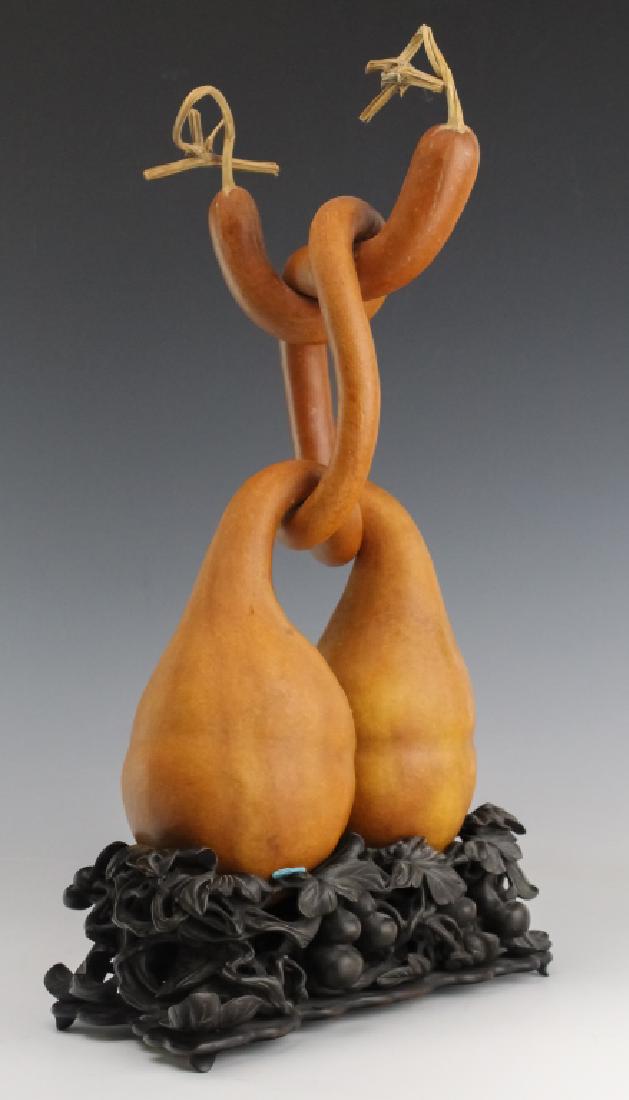 Japanese Antique Double Knotted Gourd Sculpture: Antique Japanese Meiji period natural gourd sculpture. Double gourd with knotted necks. Comes with ornate carved vine and gourd hardwood stand. Measures 17" x 10 1/2" Good condition with mild surface
