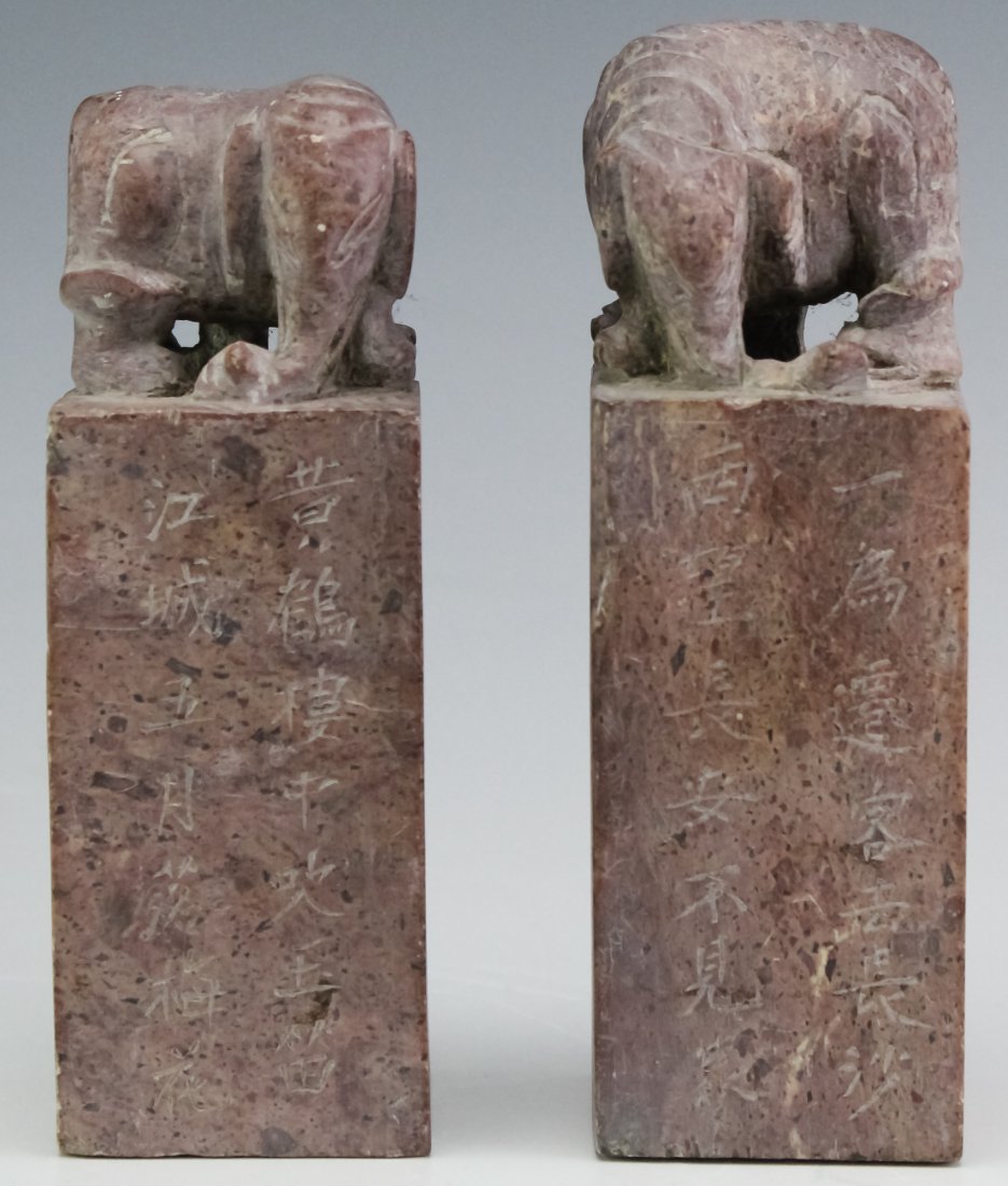 Chinese PAIR of Carved Soapstone Elephant Seals: Hand carved from light purple pink soapstone. Depicts elephants on top with engraved Chinese calligraphy. Each is carved with a different seal. Larger measures 6 3/4" x 2 1/4" Good condition with surf