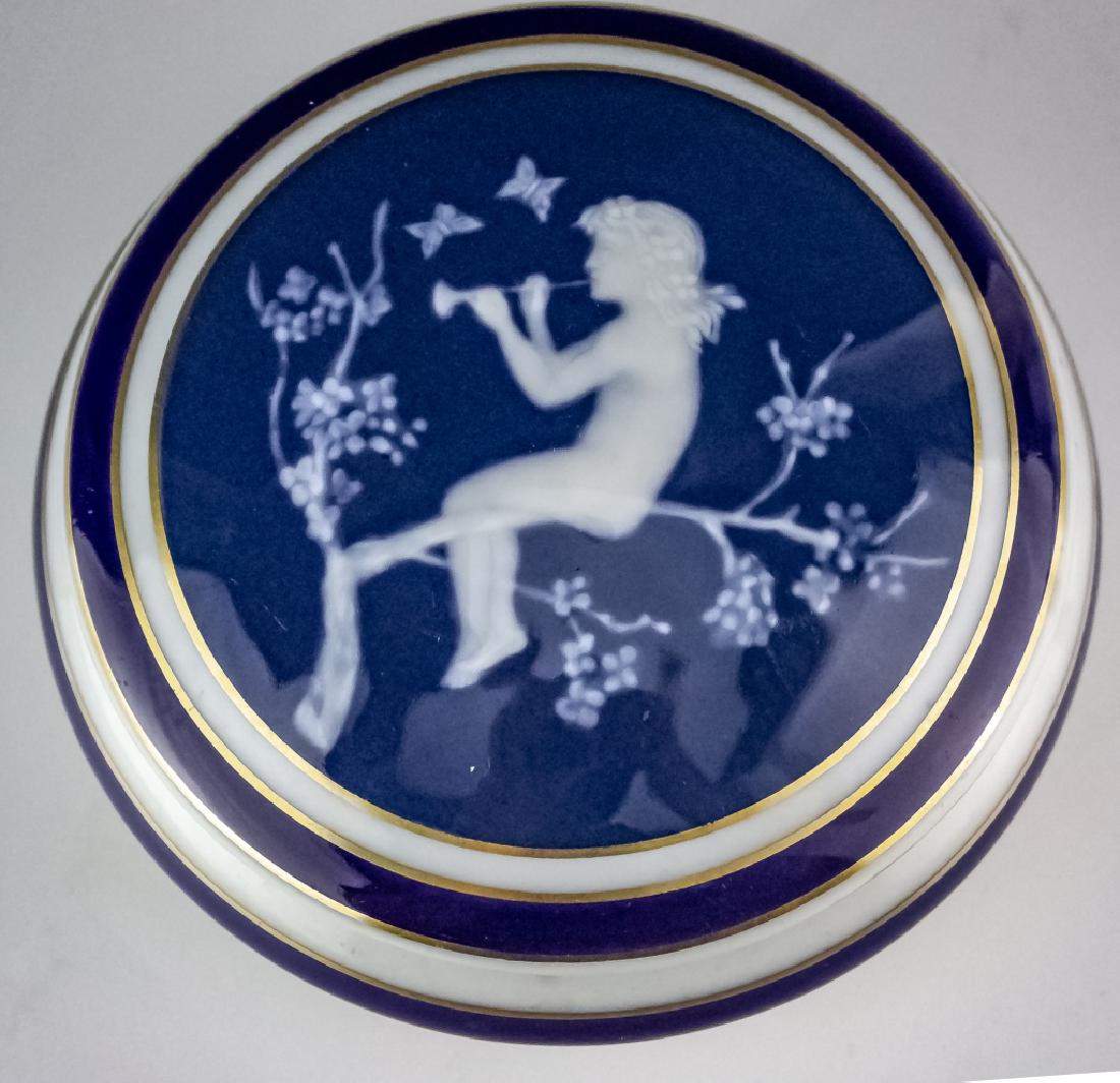 Camille Tharaud French Pate Sur Pate Porcealin Box: Vintage signed Camille Tharaud round dresser trinket box. Crafted of fine quality Limoges porcelain. Features a nude female on a flowering branch design. She is playing a musical instrument for the bu