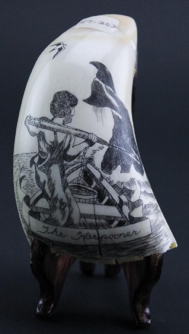 Vintage Scrimshaw Carved Harpooner Whale Tooth: Vintage carved scrimshaw whales tooth. Features the image of a whale being hunted and harpooned by a sailor in a row boat. Measures 4 1/2" x 2 1/2". Good overall condition with age related wear. Hill 