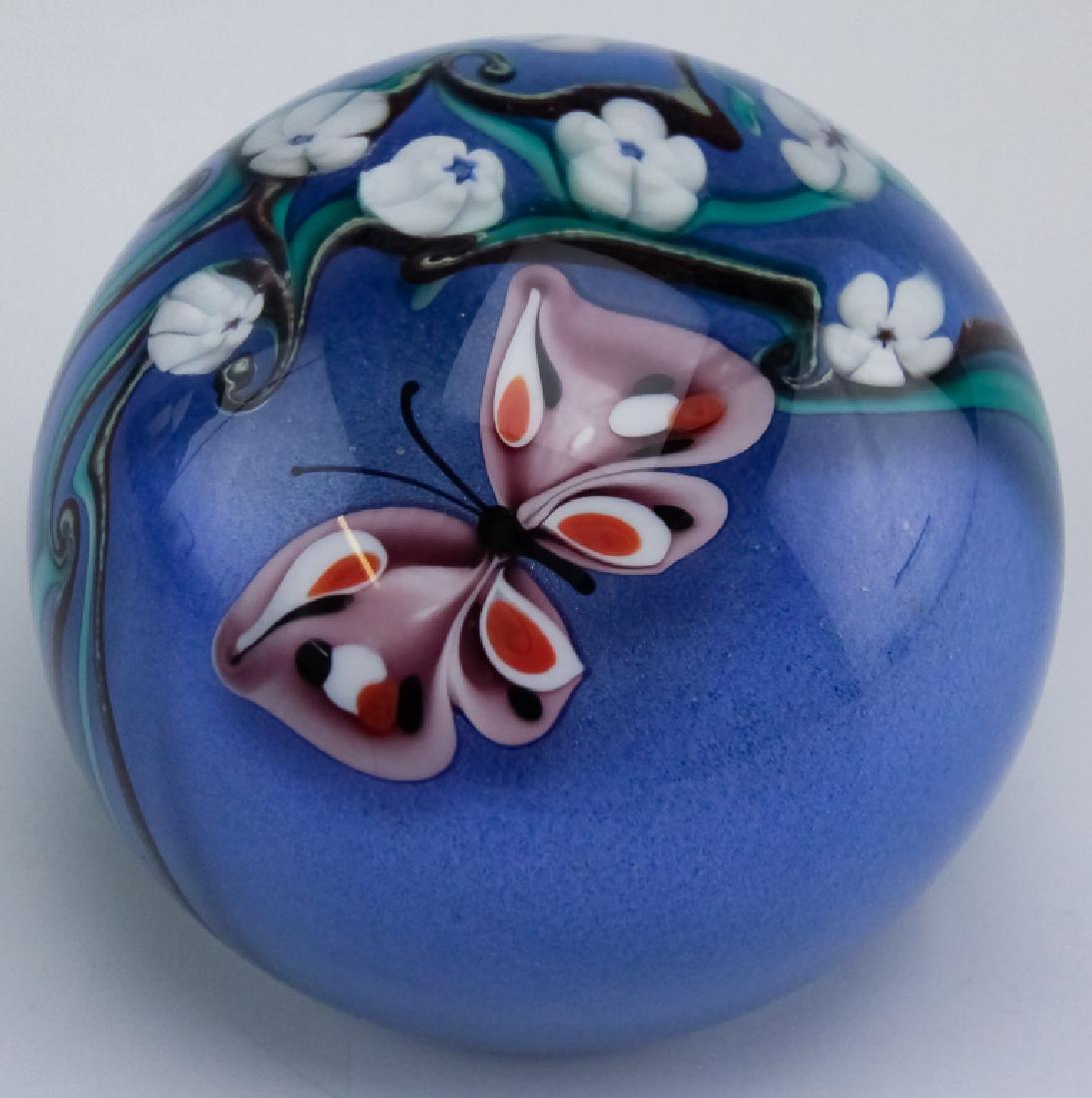 Orient & Flume Art Glass Butterfly 3" Paperweight: Guaranteed Authentic. Orient & Flume studio art glass paperweight. Features a spherical form with a multicolored butterfly with white flowers, all on a blue ground and all cased in clear crystal. Meas