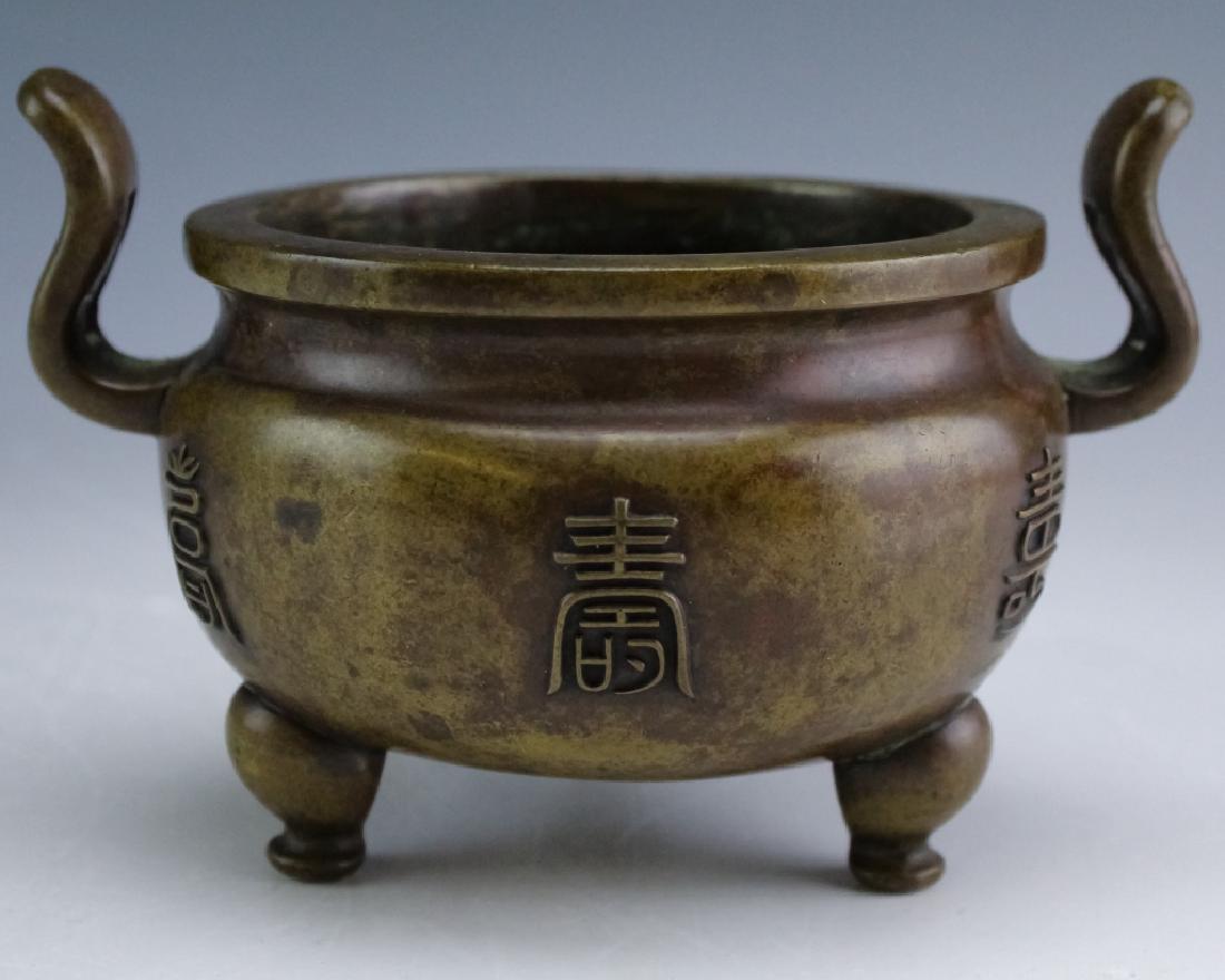 Chinese Xuande Marked Bronze Incense Burner Censor: Old Chinese bronze censor. Features a tri footed base as well as raised character marks throughout the body. The double handles are pierced and the base is marked with the Xuande character mark. Measu